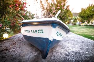 a small blue and white boat sitting on the ground at Kokkinos in Vourvourou