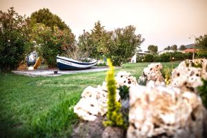 a garden with a boat in a yard at Kokkinos in Vourvourou