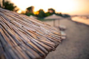 a close up of a bench with the sunset in the background at Kokkinos in Vourvourou