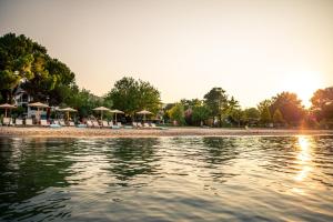 a beach with chairs and umbrellas on the water at Kokkinos in Vourvourou
