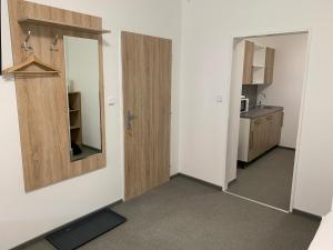 an empty room with a door and a mirror at Mikulov Inn - Apartments Slunce in Mikulov