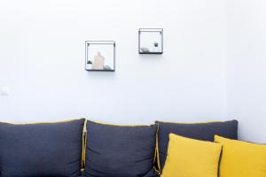 a couch with two pictures on a white wall at Kokkinos in Vourvourou