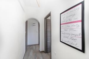 a hallway with a painting on the wall and a mirror at Kokkinos in Vourvourou