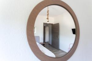 a mirror reflecting a room with a bed and a hallway at Kokkinos in Vourvourou