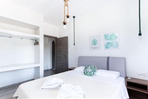 a bedroom with two white beds and a window at Kokkinos in Vourvourou
