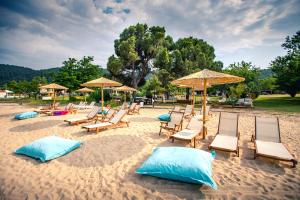 a group of chairs and umbrellas on a beach at Kokkinos in Vourvourou