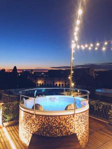 una vasca idromassaggio seduta su una terrazza con luci di Rooftop Colosseo - Roma d'Amore a Roma
