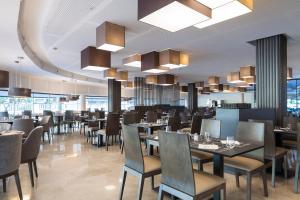 restauracja ze stołami, krzesłami i żyrandolami w obiekcie Hotel Bristol 4 Sup w mieście Benidorm