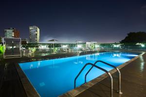 a large swimming pool at night with a city at Kwarleyz Residence, Accra in Accra