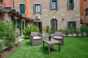 a patio with two chairs and a table and a building at Corte dei Santi in Venice