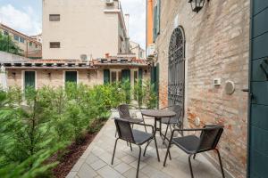 a patio with chairs and a table and a fence at Corte dei Santi in Venice