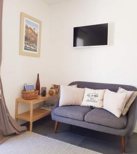 Chambre d'hôtes LE SECADOU في لاسيوتا: غرفة معيشة مع أريكة زرقاء وطاولة
