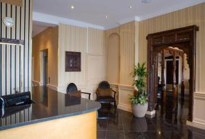 a lobby with a counter and chairs in a building at New Linden Hotel in London