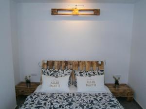 a bedroom with a bed with a wooden headboard and pillows at Alles Paletti mit Klimaanlage in Lutherstadt Wittenberg