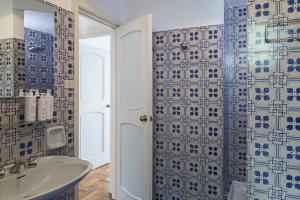 y baño con lavabo y ducha con azulejos azules y blancos. en Casa Bianca a Bogliasco by Wonderful Italy, en Bogliasco