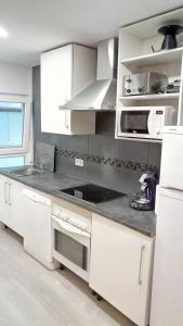 a kitchen with white cabinets and a counter top at Bnap Masip in Oviedo