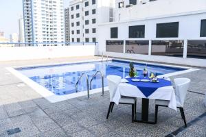 a table and chairs next to a swimming pool at Juffair Grand Hotel in Manama