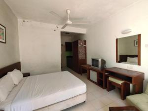 een slaapkamer met een bed, een bureau en een televisie bij Jana View Condotel MN in Kamunting