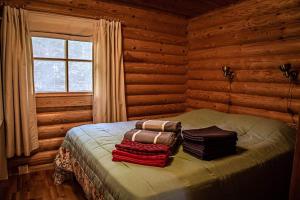 a bedroom with a bed in a log cabin at Villa Omena at MESSILA ski & camping in Hollola