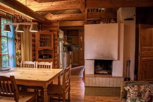 a kitchen and dining room with a table and a fireplace at Villa Omena at MESSILA ski & camping in Hollola