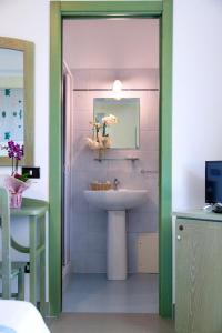a bathroom with a sink and a mirror at Hotel Cala Dei Pini in Porto Pino