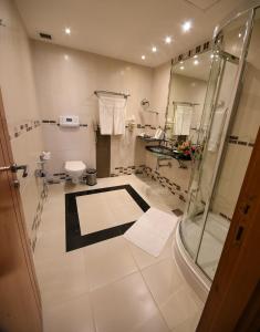 a bathroom with a shower and a toilet at Juffair Grand Hotel in Manama