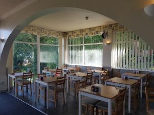 a restaurant with tables and chairs and windows at Victoria Lodge in Shanklin