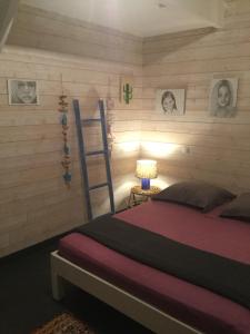 a bedroom with a bed and a ladder and pictures on the wall at Villa Shenandoah in Sainte-Anne