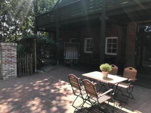 eine Terrasse mit einem Tisch und Stühlen mit einer Topfpflanze in der Unterkunft Landcafe Neumann in Bad Zwischenahn