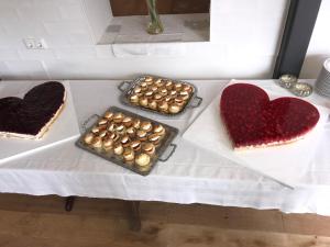 einen Tisch mit drei Kuchen und zwei Herzen darauf in der Unterkunft Landcafe Neumann in Bad Zwischenahn + 5 Fotos