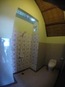 a bathroom with a shower and a toilet at Krisna Bungalows and Restaurant in Sekotong +37 photos