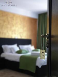 um quarto com uma cama com almofadas verdes e brancas em Spell Hotels em Căpăţîneni-Pămînteni