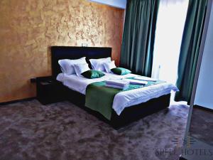 Căpăţîneni-PămînteniにあるSpell Hotelsのベッドルーム1室(緑と白の枕が備わるベッド1台付)
