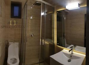 a bathroom with a toilet and a sink and a shower at Spell Hotels in Căpăţîneni-Pămînteni