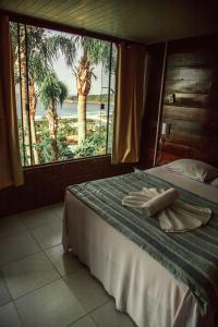 a bedroom with a bed with a view of the ocean at Pousada Estação Baleia in Praia do Rosa +56 photos