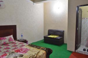 1 dormitorio con 1 cama y 1 silla en Lahore Hotel, en Swat