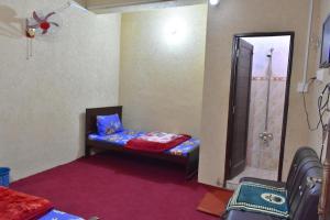 a small room with a bed and a shower at Lahore Hotel in Swat