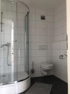 a bathroom with a toilet and a glass shower at Libarty Appartments in Kornwestheim +38 photos