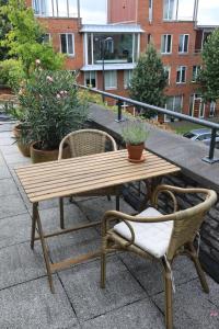 een houten tafel en stoelen op een patio met planten bij B&B De Zwanebloem in Amsterdam