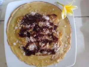 a white plate with a doughnut with a flower on it at Karta House in Ubud