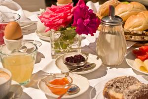 una tavola con vaso di fiori e piatti di cibo di Pension Sonnheim a Gargazzone