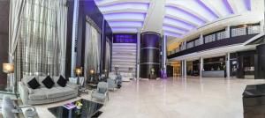 duży hol z klatką schodową w budynku w obiekcie The Juffair Grand Hotel w mieście Manama