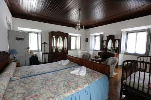 um quarto com uma cama grande num quarto com janelas em Vila Casa Do Sobral em Óbidos