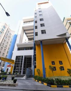 un edificio blanco y amarillo en una ciudad en The Juffair Grand Hotel, en Manama