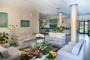 a living room filled with furniture and flowers at Hotel Cala Dei Pini in Porto Pino