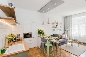 a kitchen with white walls and a table and chairs at APT with sunny garden Prague by Michal&Friends in Prague