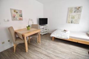 a small room with a desk and a bed and a table at Ferienwohnung Troisdorf in Troisdorf