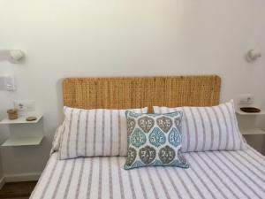 a bed with striped sheets and pillows in a bedroom at Ses Terrasses in Cadaqués
