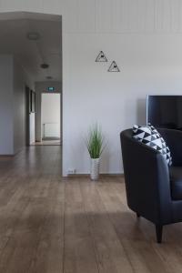 a living room with a black couch and wooden floors at Guesthouse Brekka in Brekka