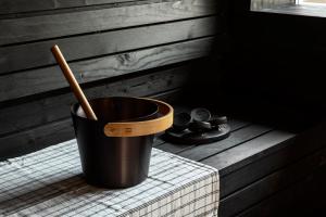 a bucket with a wooden spoon in it next to a fireplace at Lamasu RioVerde - Lago di Garda in San Felice del Benaco